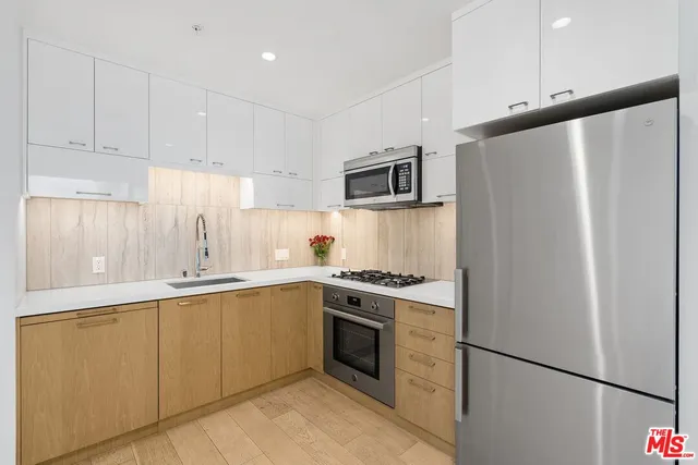 a kitchen with stainless steel appliances a refrigerator sink and microwave