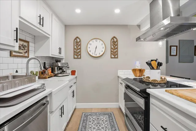 a kitchen with stainless steel appliances granite countertop a stove a sink and a refrigerator