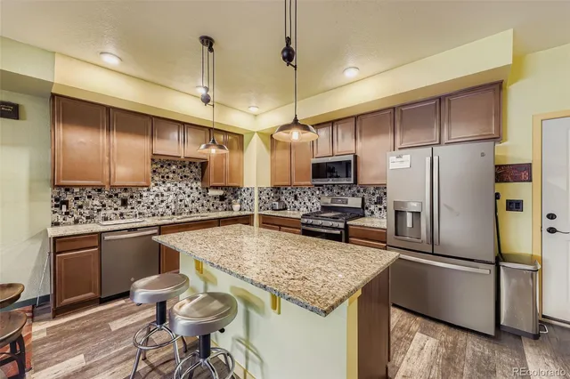 a kitchen with a center island and stainless steel appliances