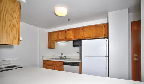 a kitchen with stainless steel appliances granite countertop a refrigerator a sink and a stove with wooden floor