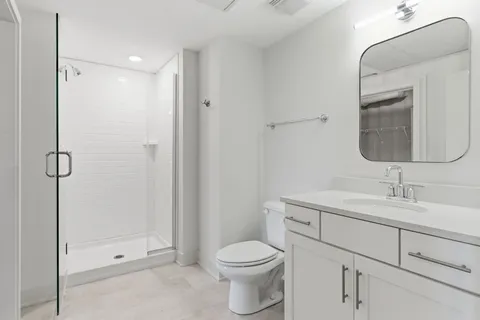 a bathroom with a toilet sink vanity and mirror
