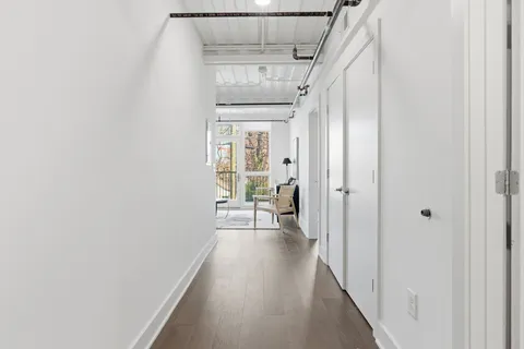 a view of a hallway with wooden floor and staircase