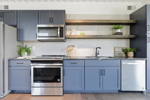 a kitchen with cabinets stainless steel appliances and wooden floor