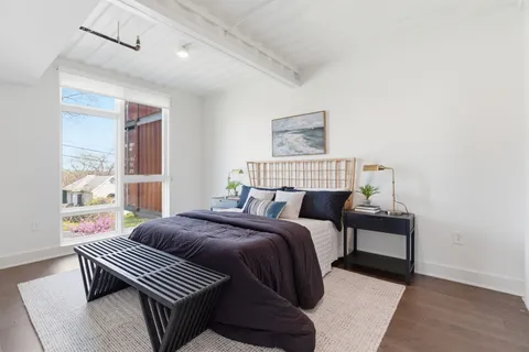 a bedroom with a bed and wooden floor