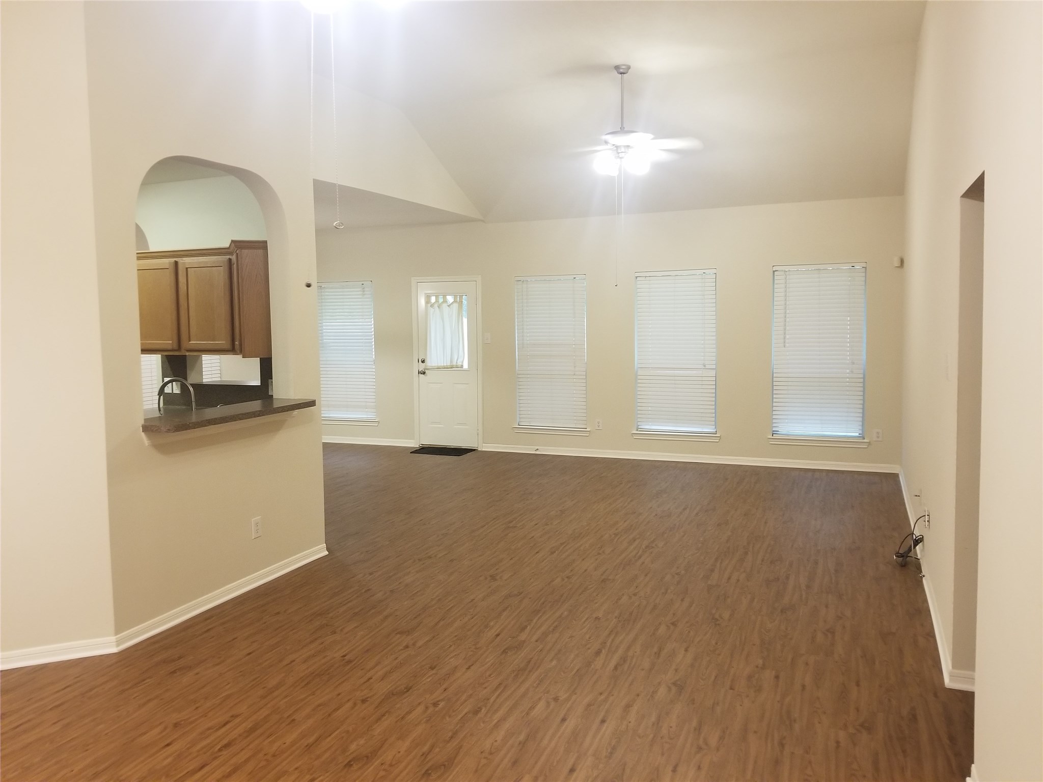 2406 Hawks Road Missouri City, TX 77489 - Photo 14 of 29 a view of an empty room and kitchen with wooden floor