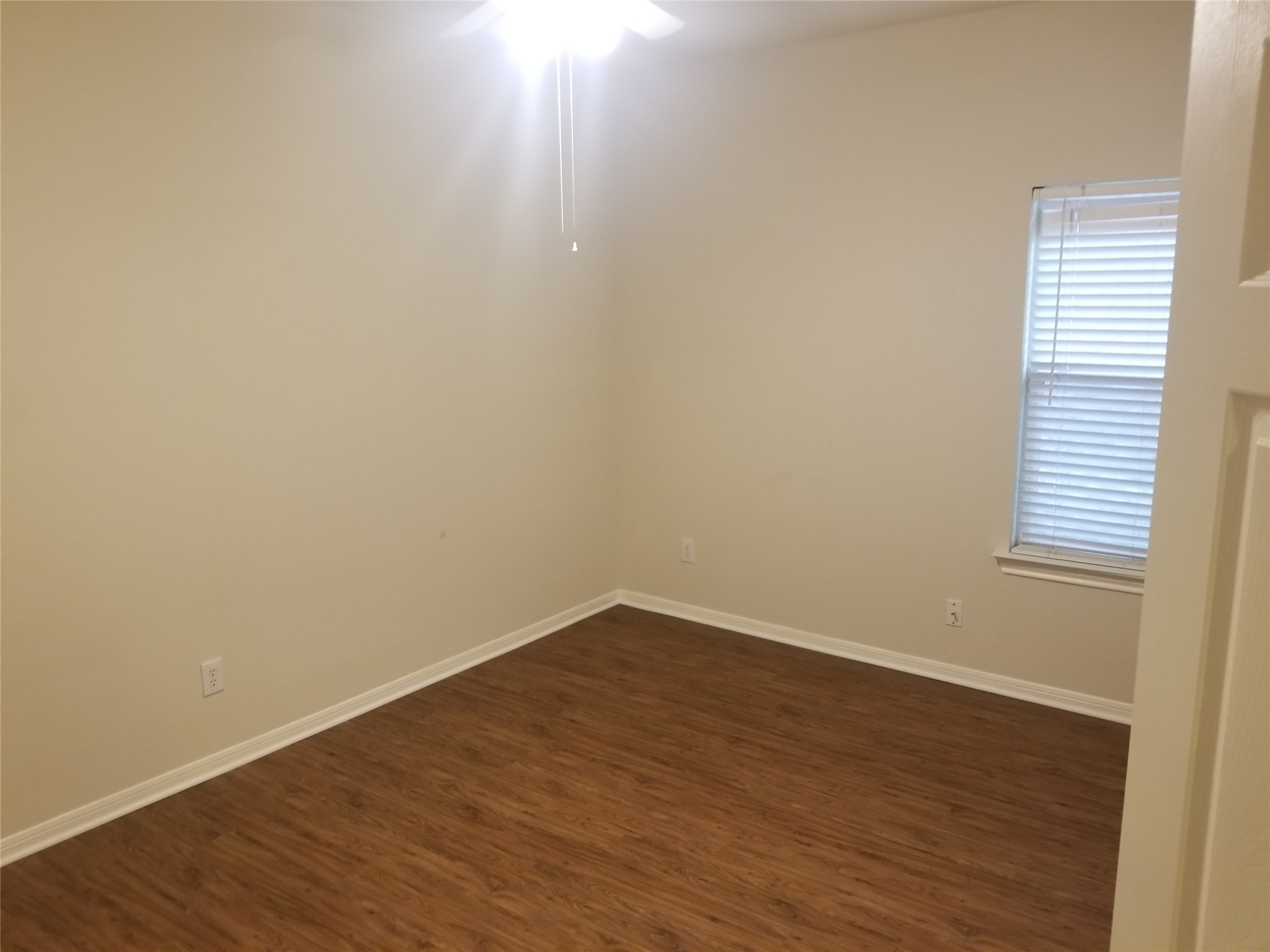 2406 Hawks Road Missouri City, TX 77489 - Photo 18 of 29 a view of an empty room with wooden floor and a window