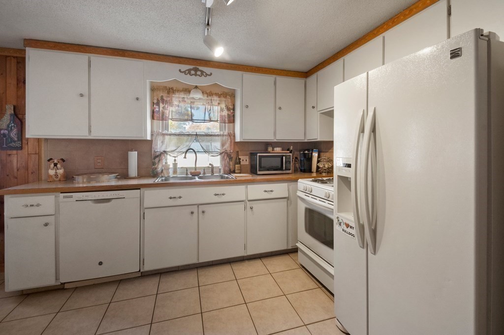 46 Timber Lane Springfield, MA 01119 - Photo 9 of 42 a kitchen with white cabinets a refrigerator and a sink