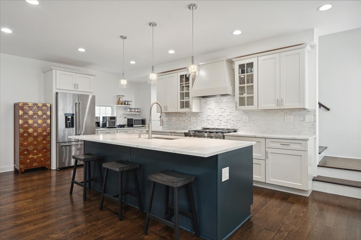 880 Willow Road Winnetka, IL 60093 - Photo 3 of 23 a kitchen with stainless steel appliances granite countertop a sink a stove a refrigerator and island with wooden floor