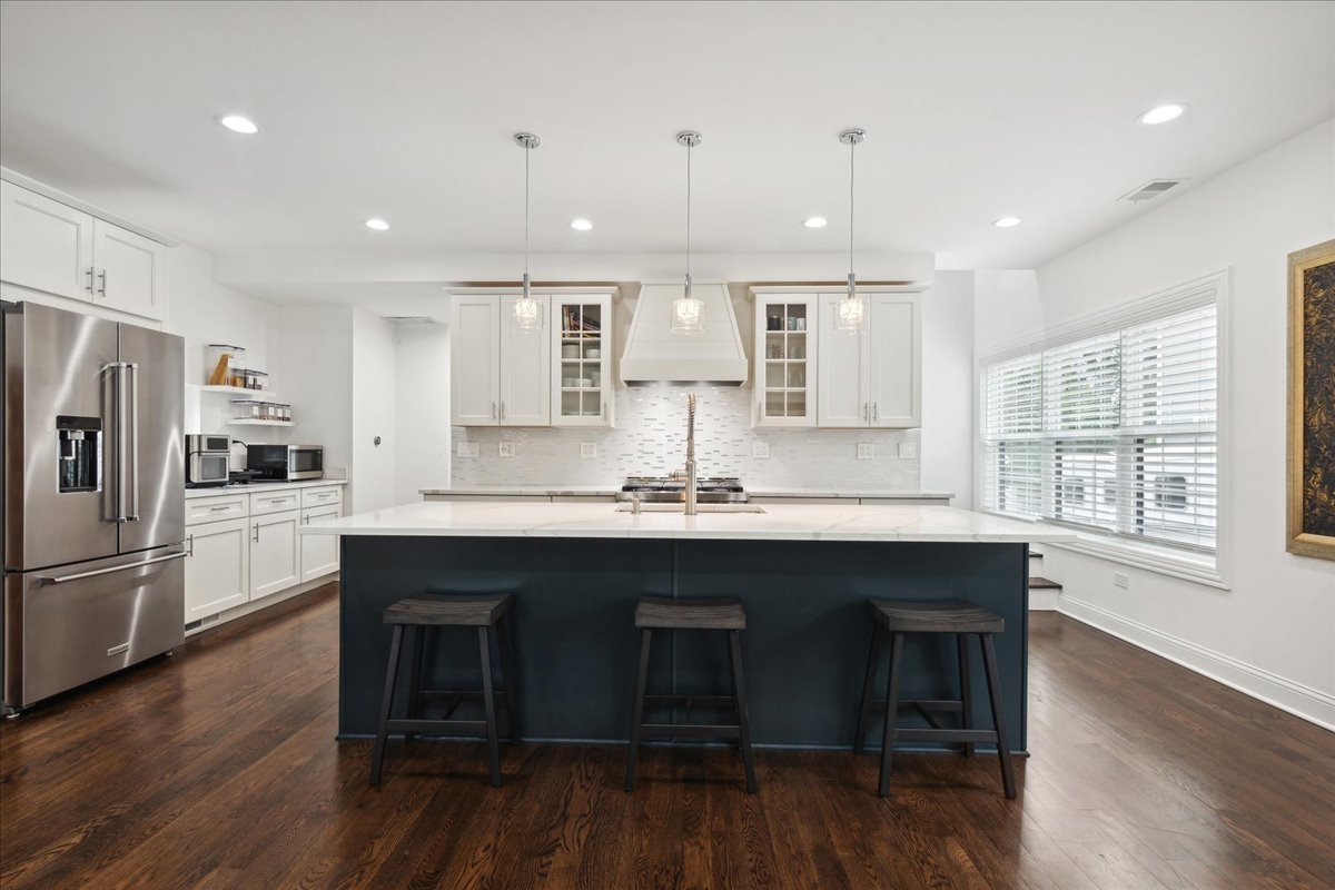 880 Willow Road Winnetka, IL 60093 - Photo 4 of 23 a kitchen with stainless steel appliances granite countertop a sink a stove a refrigerator and island with wooden floor