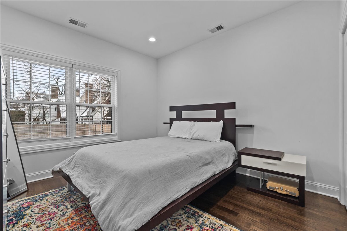 880 Willow Road Winnetka, IL 60093 - Photo 7 of 23 a bedroom with a bed a large window with outer view and chair