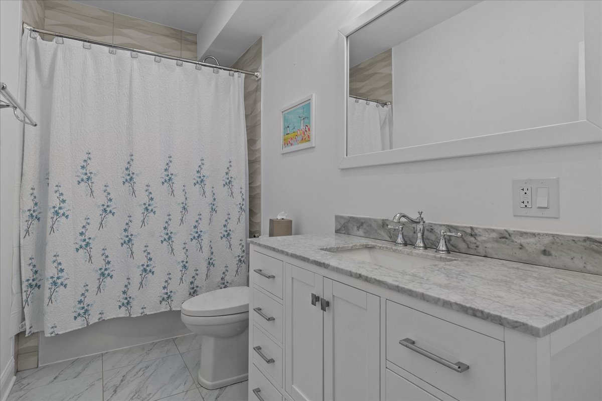 880 Willow Road Winnetka, IL 60093 - Photo 9 of 23 a bathroom with a granite countertop sink a toilet and a mirror
