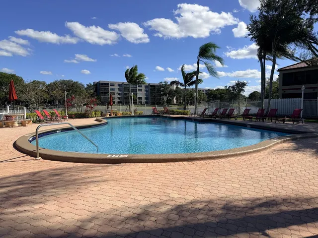 a front view of a house with a yard and palm tree
