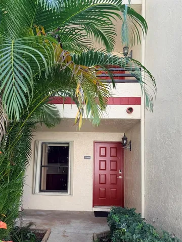 a view of an empty room with wooden floor and a large window