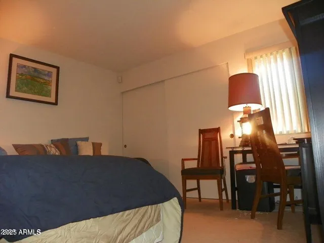 a bedroom with a bed and a lamp next to a window