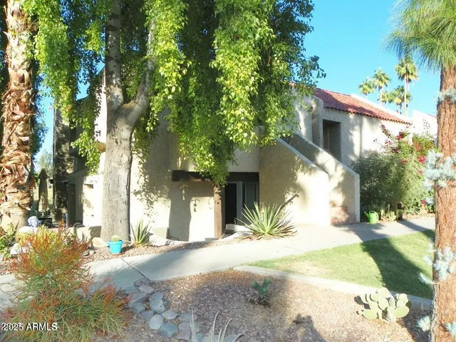 a view of a house with a tree in the background