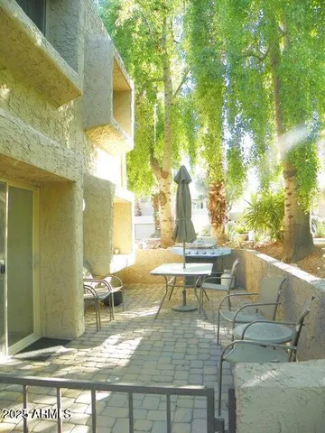 a view of a patio with table and chairs and potted plants