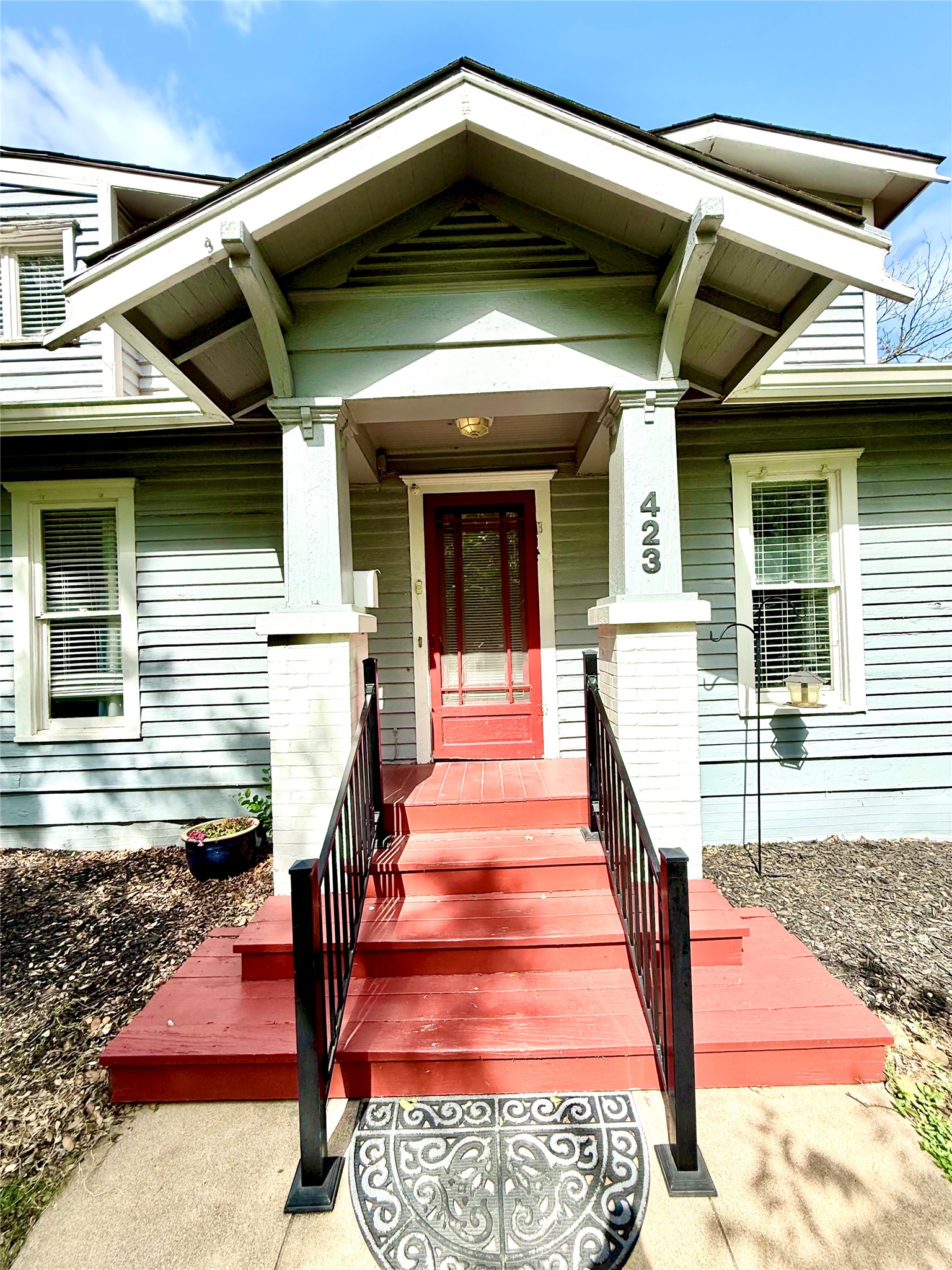 423 South Main Street Lockhart, TX 78644 - Photo 3 of 26 Inviting front porch with a vibrant red entry door and coordinating steps