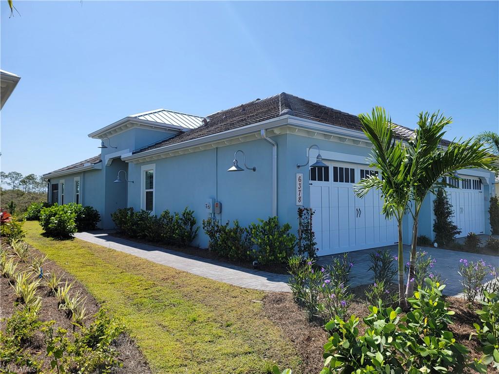 6378 Negril Isle Drive Naples, FL 34113 - Photo 2 of 15 a front view of a house with garden