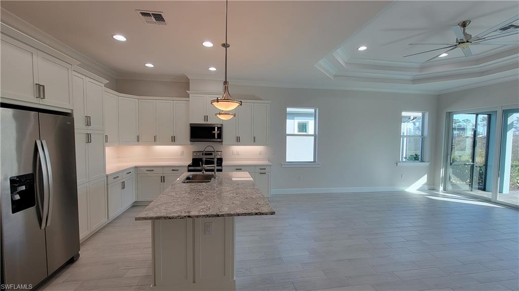6378 Negril Isle Drive Naples, FL 34113 - Photo 4 of 15 a kitchen with refrigerator a stove and wooden floor