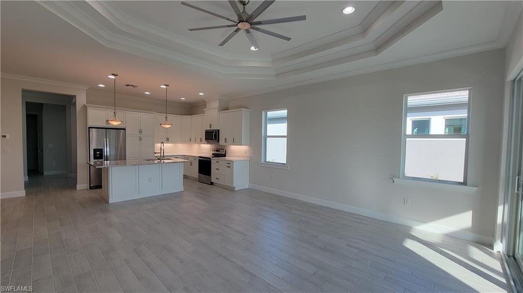 6378 Negril Isle Drive Naples, FL 34113 - Photo 6 of 15 a view of kitchen with kitchen island white cabinetry and refrigerator