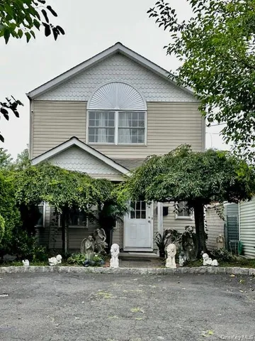 a view of a house with a yard and sitting area