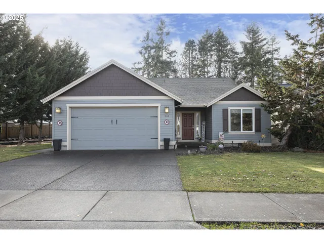 a view of a house with a yard and large tree