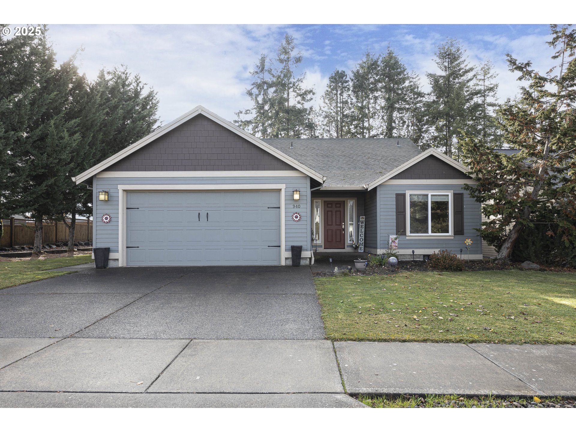 a view of a house with a yard and large tree