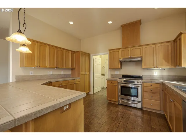 a kitchen with stainless steel appliances a stove a refrigerator and a sink