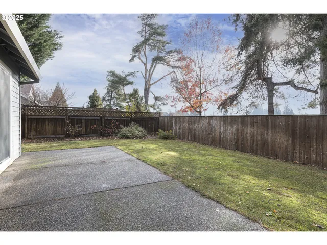 a view of backyard with wooden fence