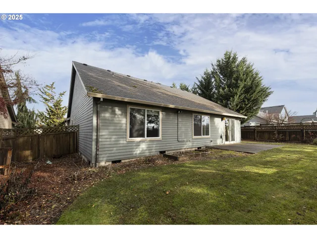 a backyard of a house with wooden floor and fence