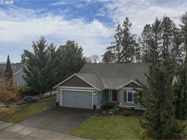 an aerial view of house with yard and trees in the background