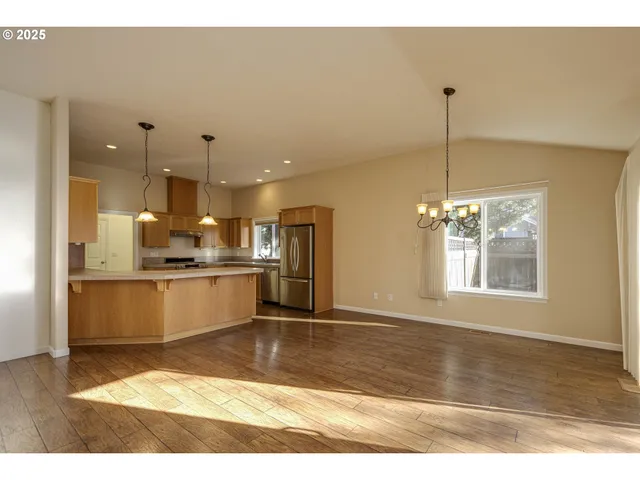 a view of a kitchen with kitchen island a counter top space appliances and cabinets