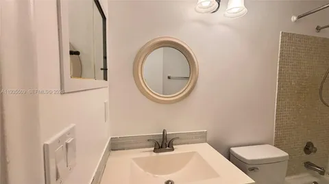 a bathroom with a sink a toilet and a mirror