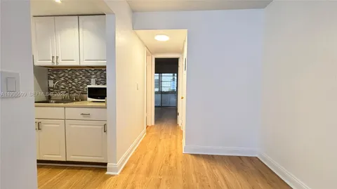 a view of a kitchen with wooden floor and cabinets
