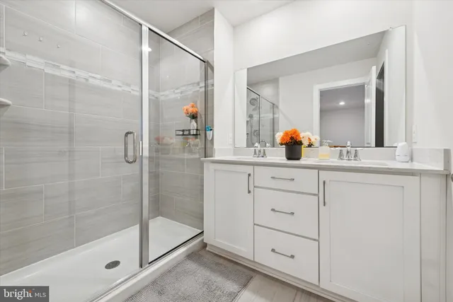 a bathroom with a shower sink and mirror