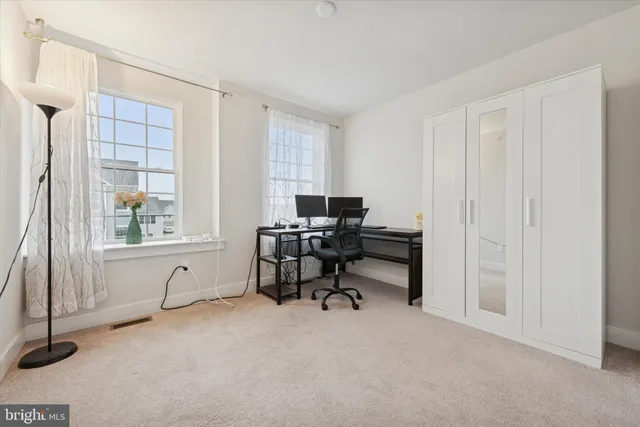 a view of a workspace with furniture and a window