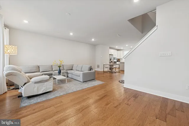 a living room with furniture and a wooden floor