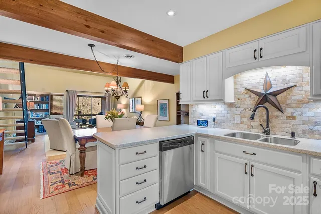a kitchen with stainless steel appliances white cabinets and a stove top oven