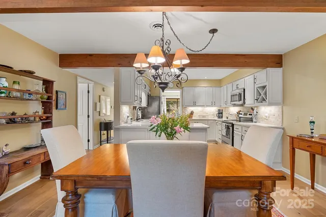 a living room with dining room and chandelier