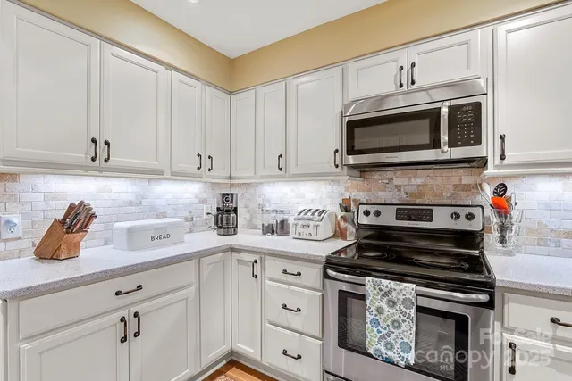 a kitchen with cabinets stainless steel appliances and a counter space