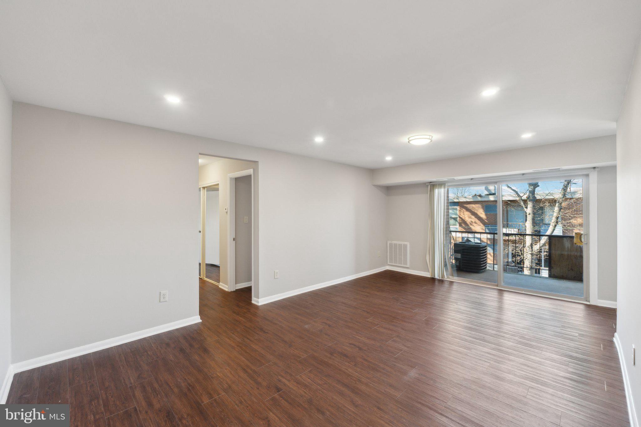 3809 St Barnabas Road, Unit T202 Suitland, MD 20746 - Photo 1 of 20 a view of a big room with wooden floor and windows