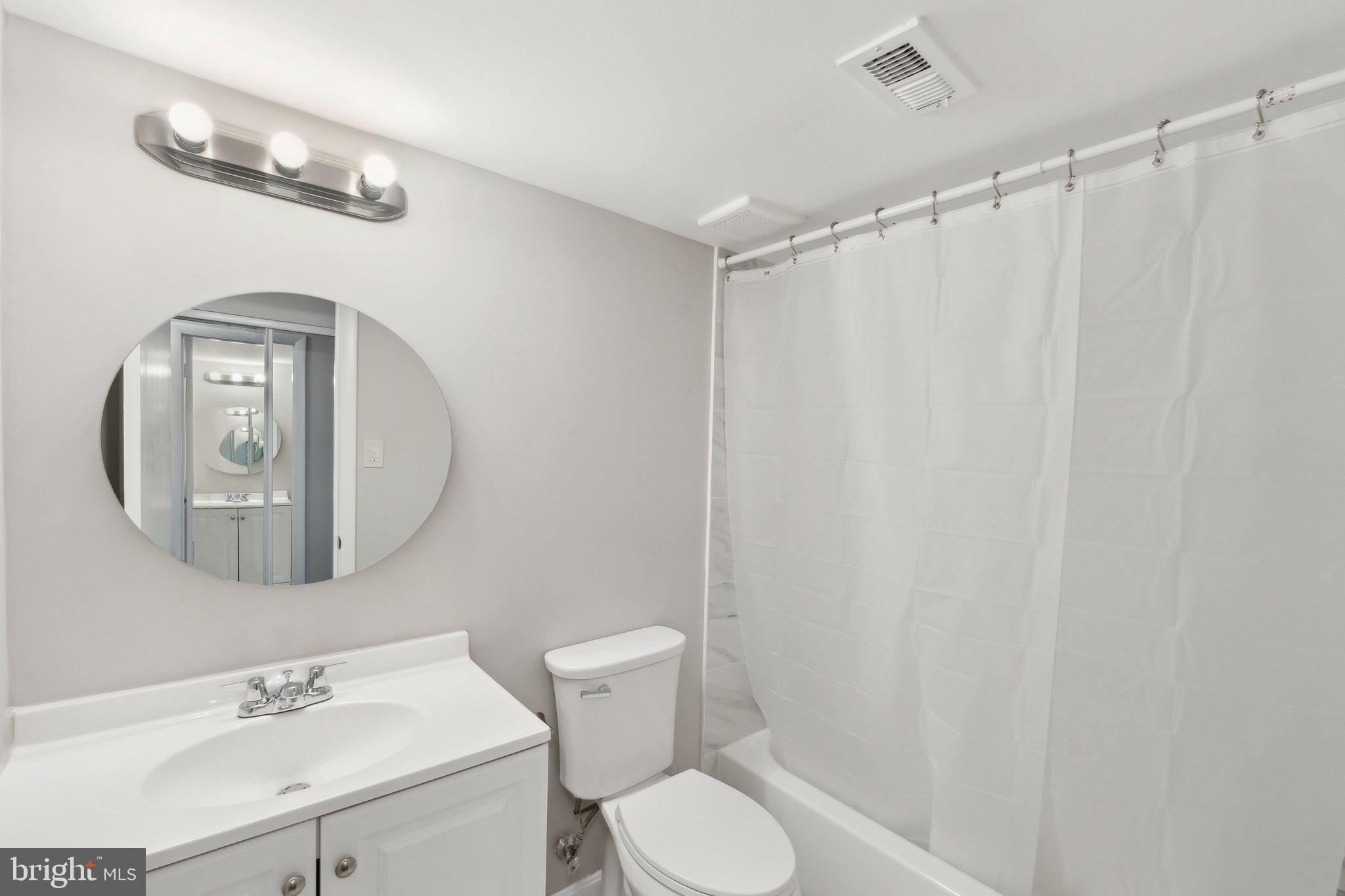 3809 St Barnabas Road, Unit T202 Suitland, MD 20746 - Photo 14 of 20 a bathroom with a sink mirror and a toilet