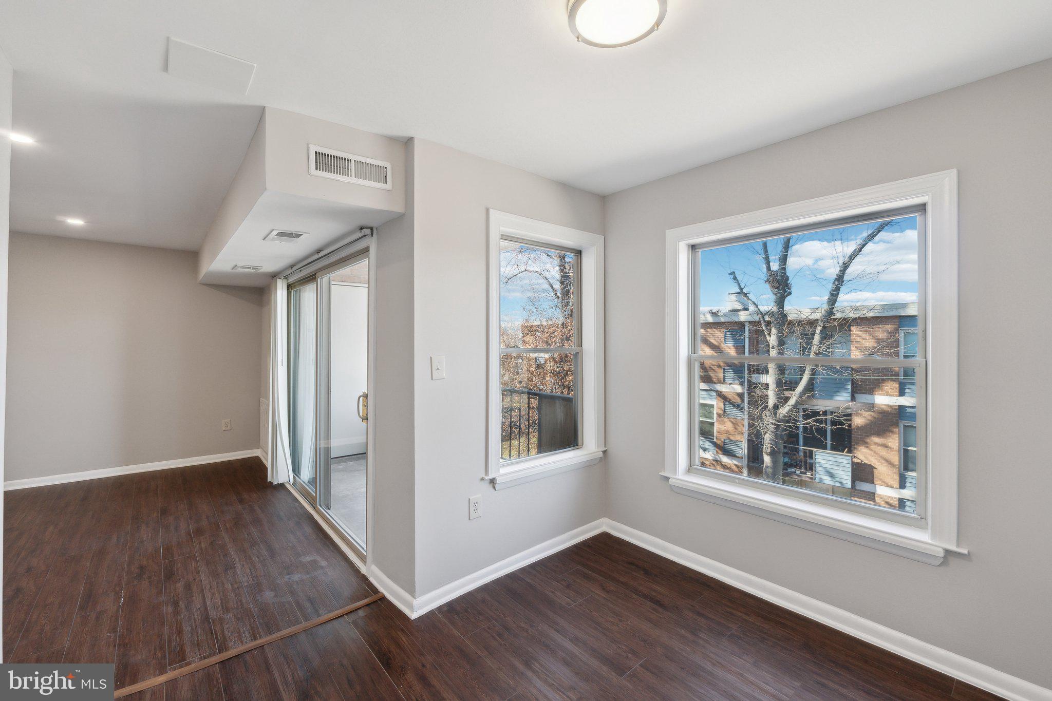 3809 St Barnabas Road, Unit T202 Suitland, MD 20746 - Photo 7 of 20 a view of an empty room with wooden floor and a window