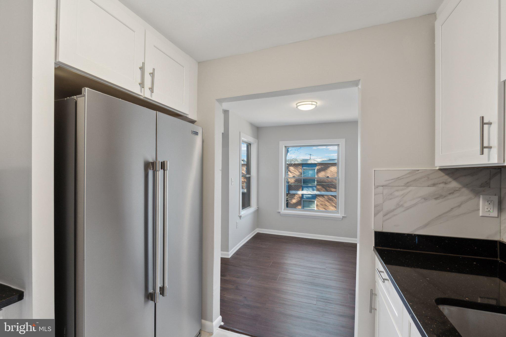 3809 St Barnabas Road, Unit T202 Suitland, MD 20746 - Photo 8 of 20 a view of a kitchen with wooden floor electronic appliances and windows