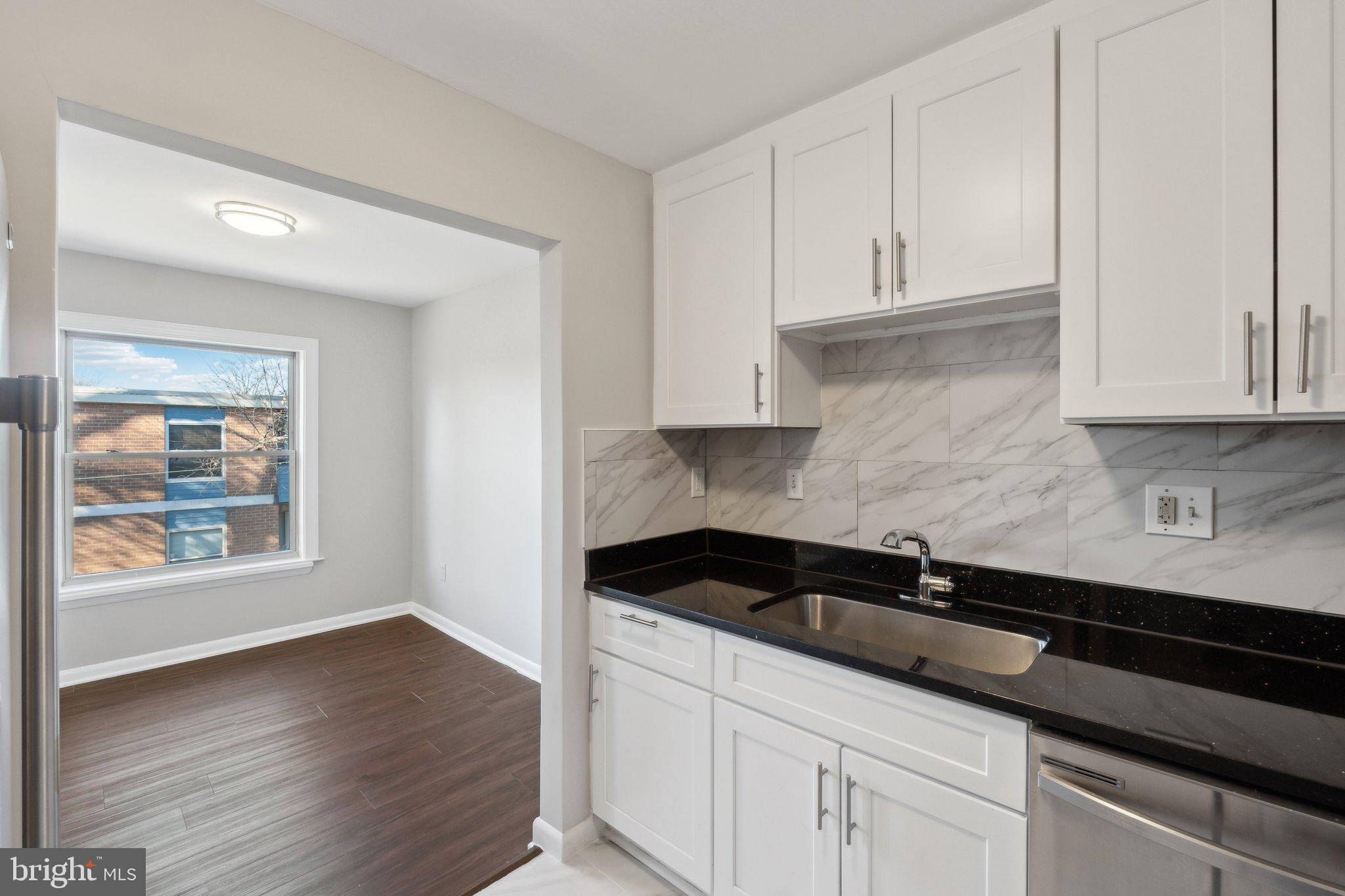 3809 St Barnabas Road, Unit T202 Suitland, MD 20746 - Photo 9 of 20 a kitchen with granite countertop white cabinets and a stove