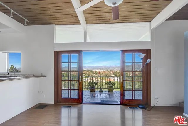 a view of empty room with wooden floor and floor to ceiling window