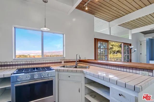 a kitchen with a stove a sink and a window