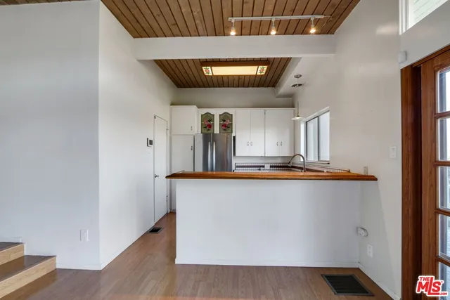a living room with stainless steel appliances wooden floor