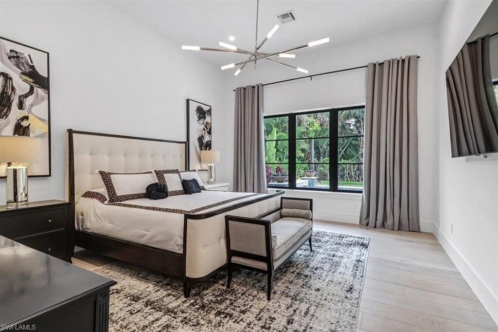 1546 Mandarin Road Naples, FL 34102 - Photo 19 of 48 Bedroom featuring a notable chandelier and light hardwood / wood-style floors