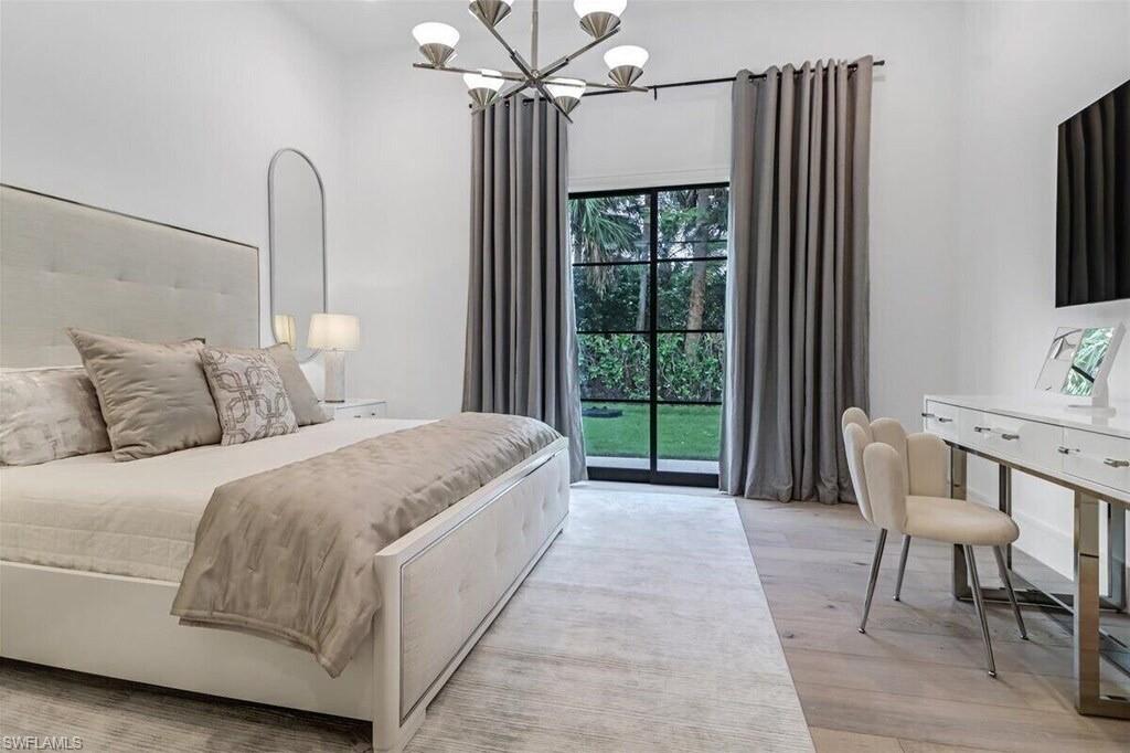 1546 Mandarin Road Naples, FL 34102 - Photo 24 of 48 Bedroom featuring a chandelier, light hardwood / wood-style flooring, and access to outside